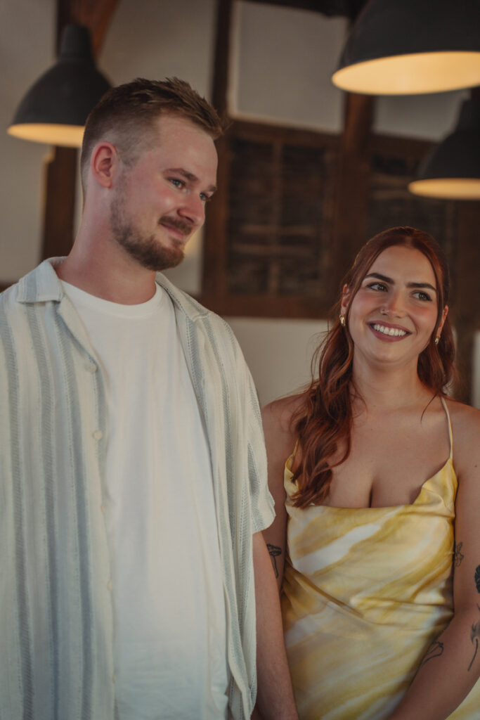 Braut und Bräutigam stehen nebeneinander im Innenraum einer Hochzeitslocation. .