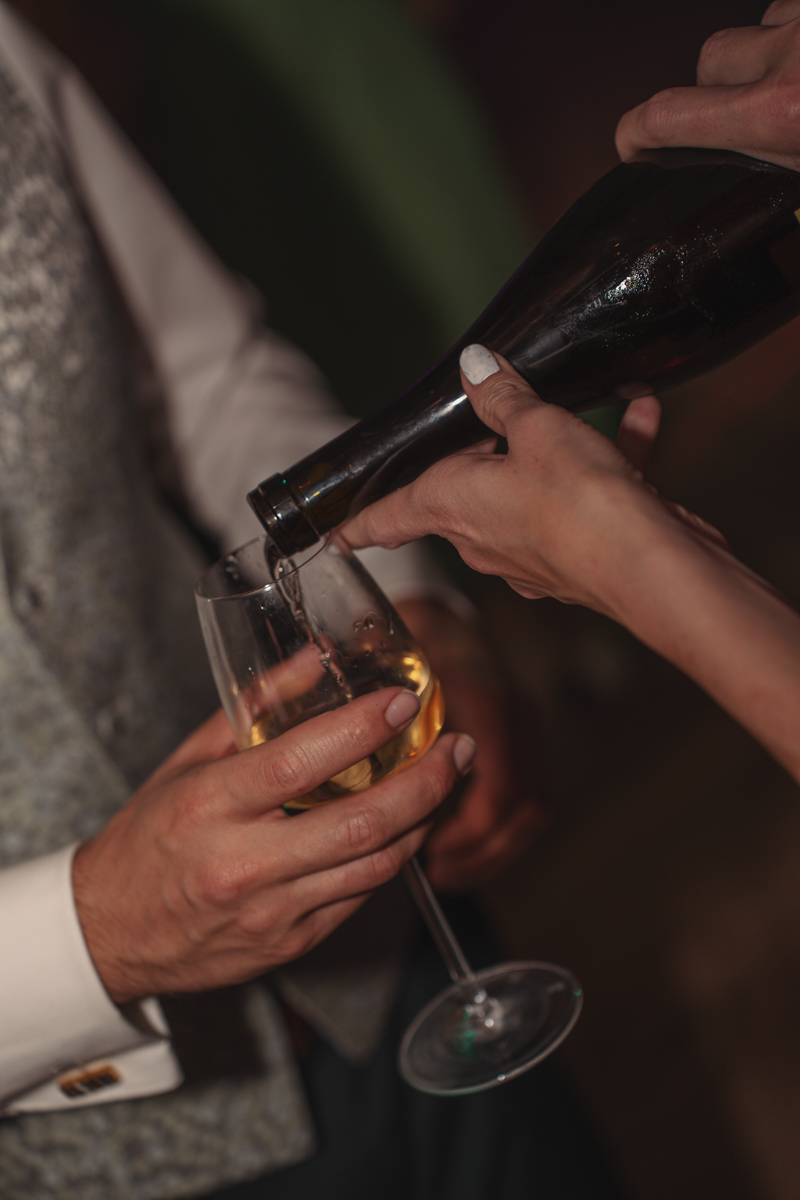 Sekt wird bei der Hochzeitsfeier in ein Glas eingeschenkt.