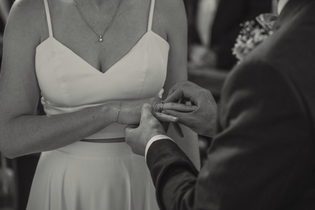Bräutigam steckt der Braut beim Ringtausch den Ehering an – emotionaler Moment der Hochzeitszeremonie.