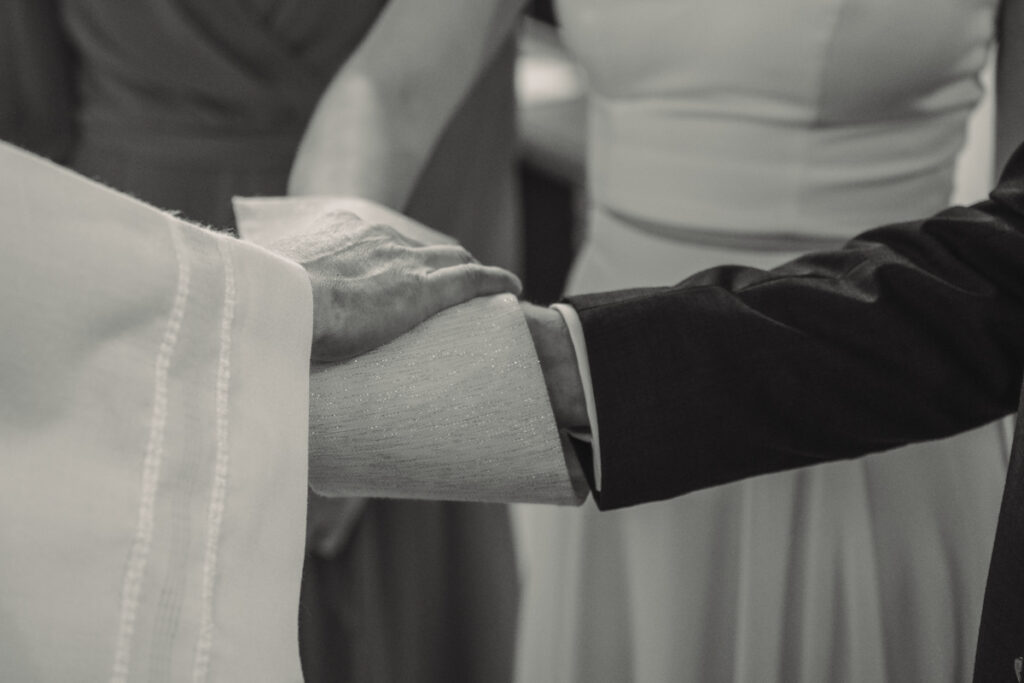 Braut und Bräutigam legen während der Zeremonie ihre Hände aufeinander.