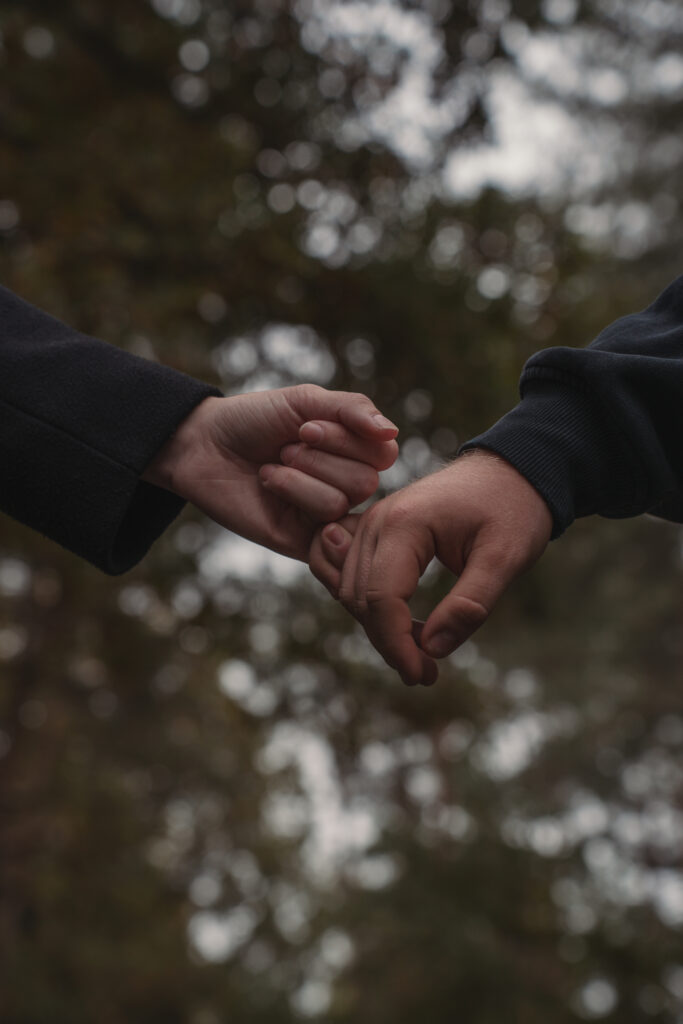 Detailaufnahme von ineinander verschränkten Händen mit Ring während eines Paarshootings.